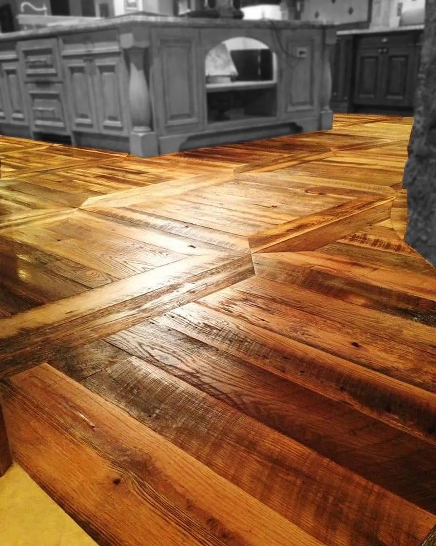 Polished wooden floor in a kitchen with gray cabinets and a built-in oven