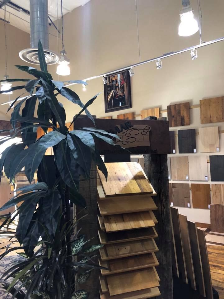 A display of wooden flooring in a store with a plant in the foreground