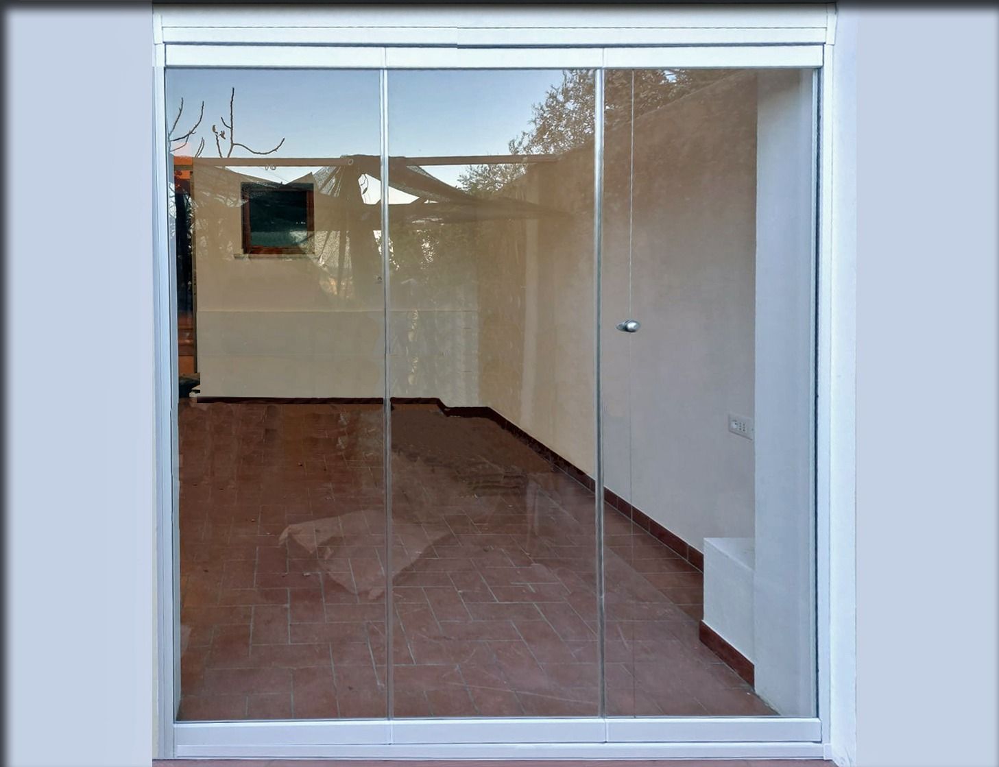 Porte scorrevoli in legno incastonate in un muro di pietra, che si aprono su un interno illuminato con impalcature visibili all'interno.