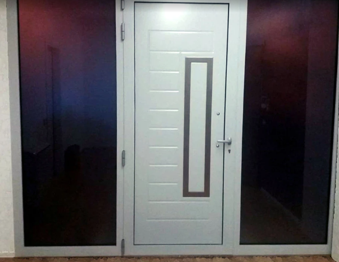 Porta d'ingresso moderna di colore bianco con una stretta finestra verticale, affiancata da pannelli in vetro scuro.