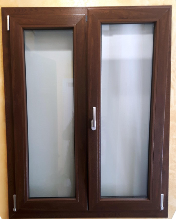 Finestra a doppia anta con telaio in legno marrone, vetro satinato e maniglie argentate.