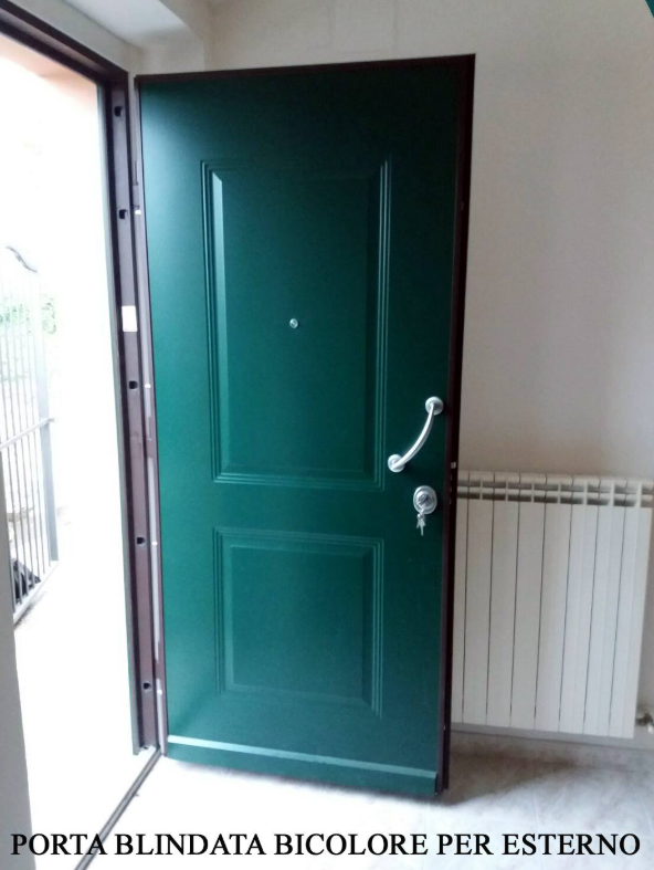 Porta blindata esterna verde parzialmente aperta accanto a un termosifone bianco all'interno