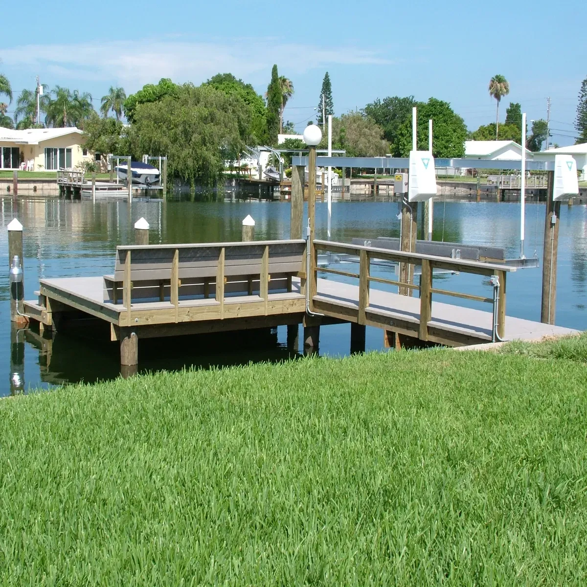A dock with a bench and a railing overlooking a body of water.
