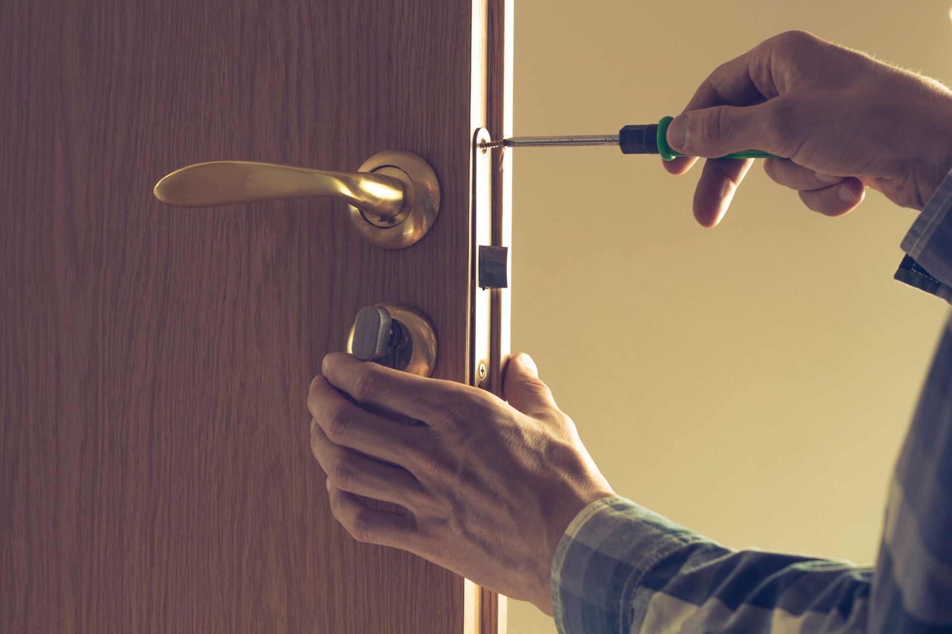 a man is fixing a door with a screwdriver