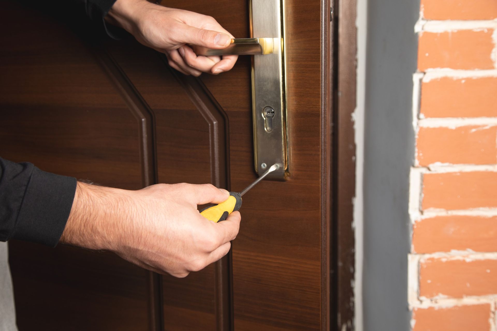 a man is fixing a door with a screwdriver