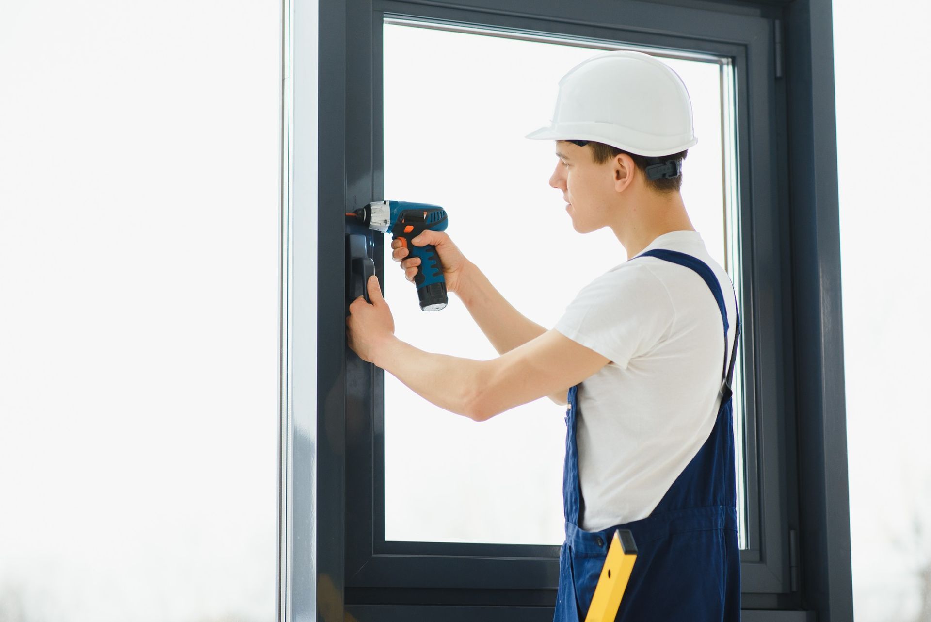a man is installing a window with a drill