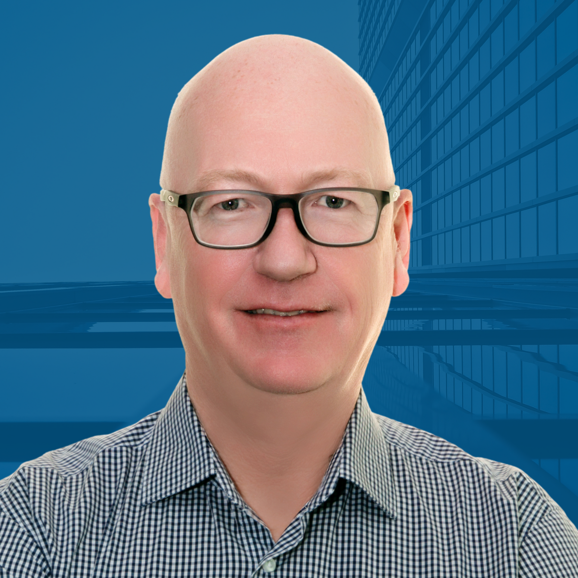 Man with glasses and a shaved head, smiling, in front of a blue background with a building outline.