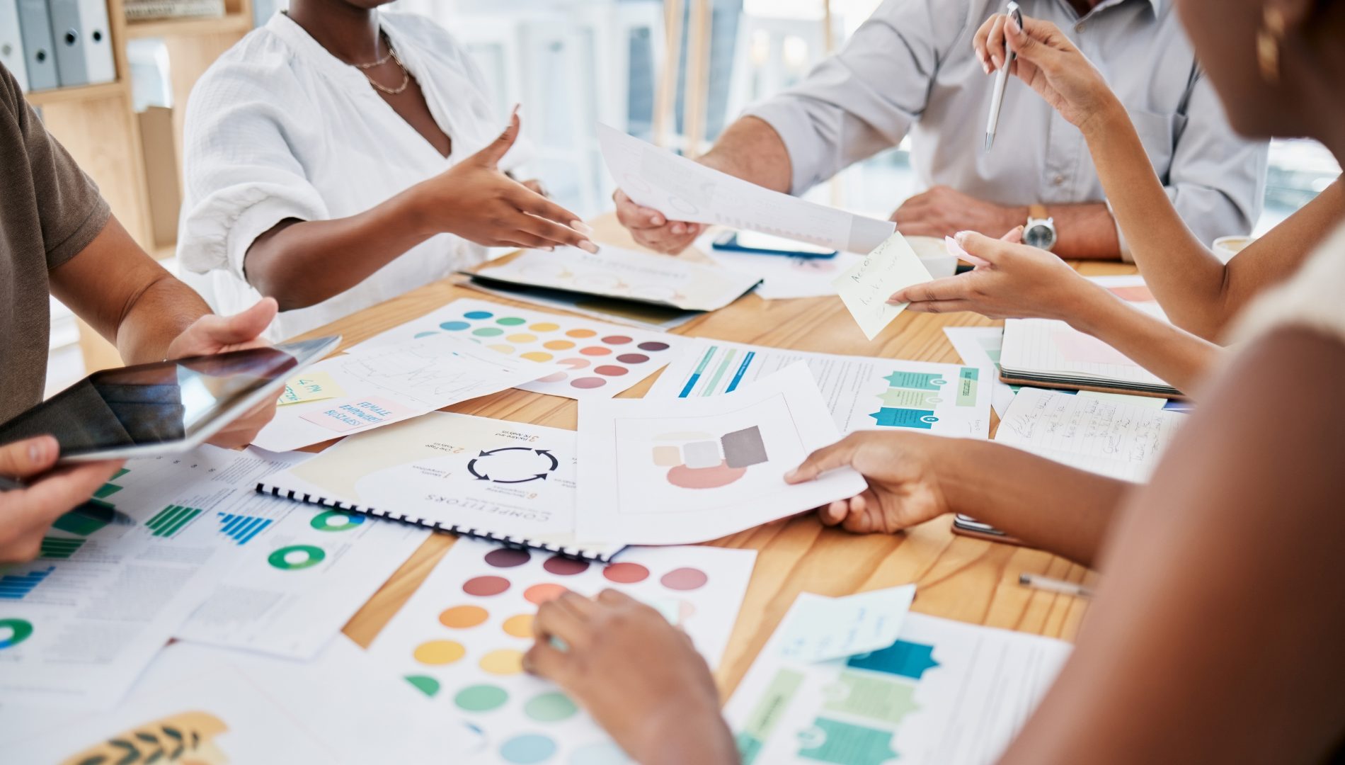 People at a table review documents, charts, and color swatches.