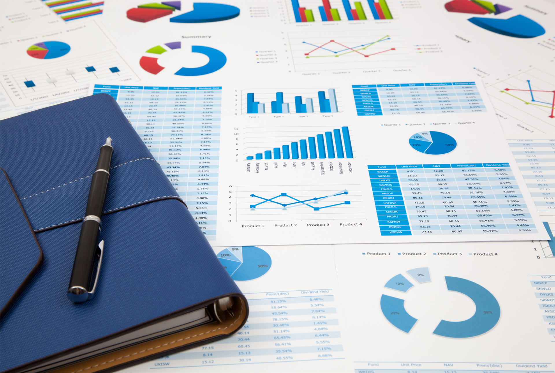 Blue notebook and pen on desk with various charts and graphs, blue and colorful.