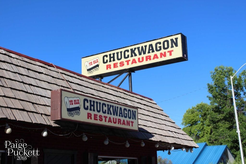 Chuckwagon Restaurant sign on a rustic building under a bright blue sky
