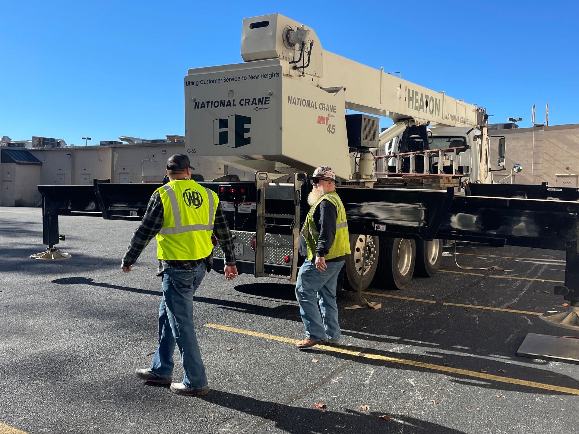 Two men are standing in front of a truck that says heavy
