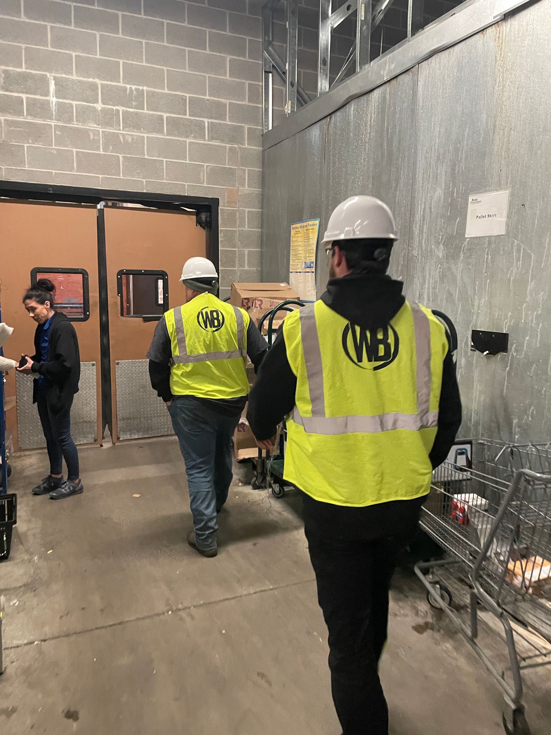 A group of construction workers are walking through a building.