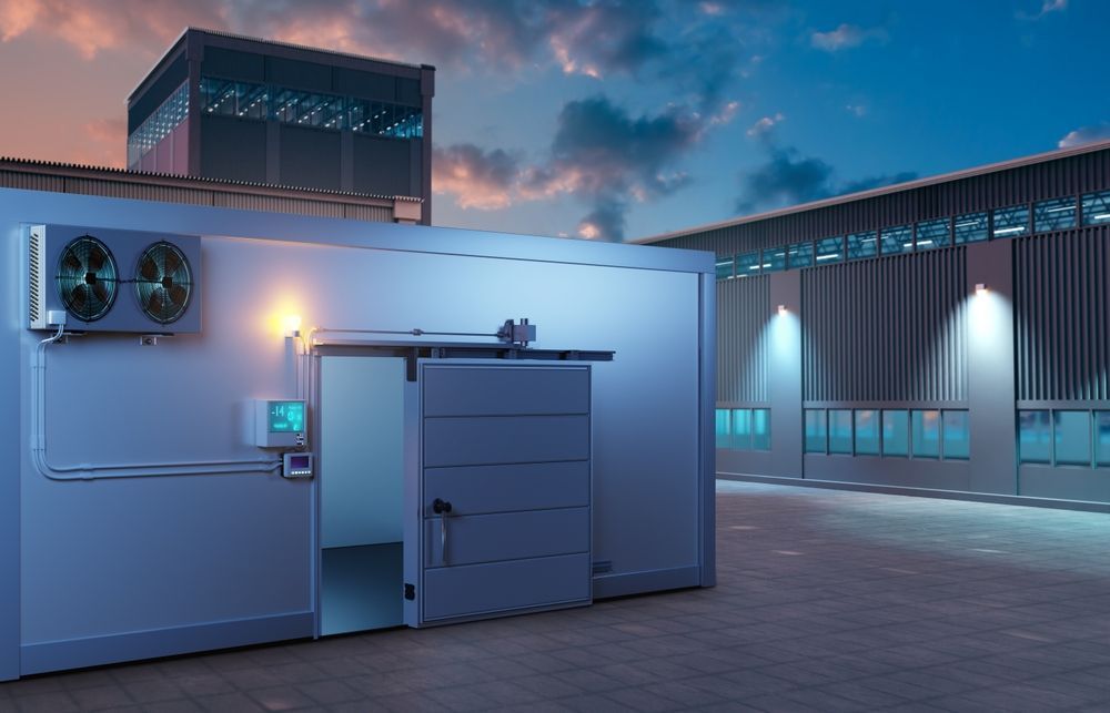 A large building with a sliding door and two fans on the side of it.