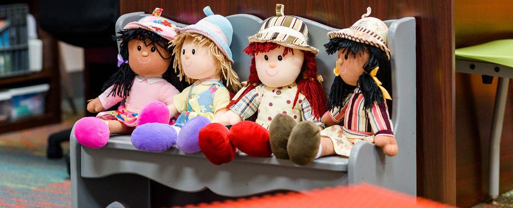 Four dolls sitting and organized in a line