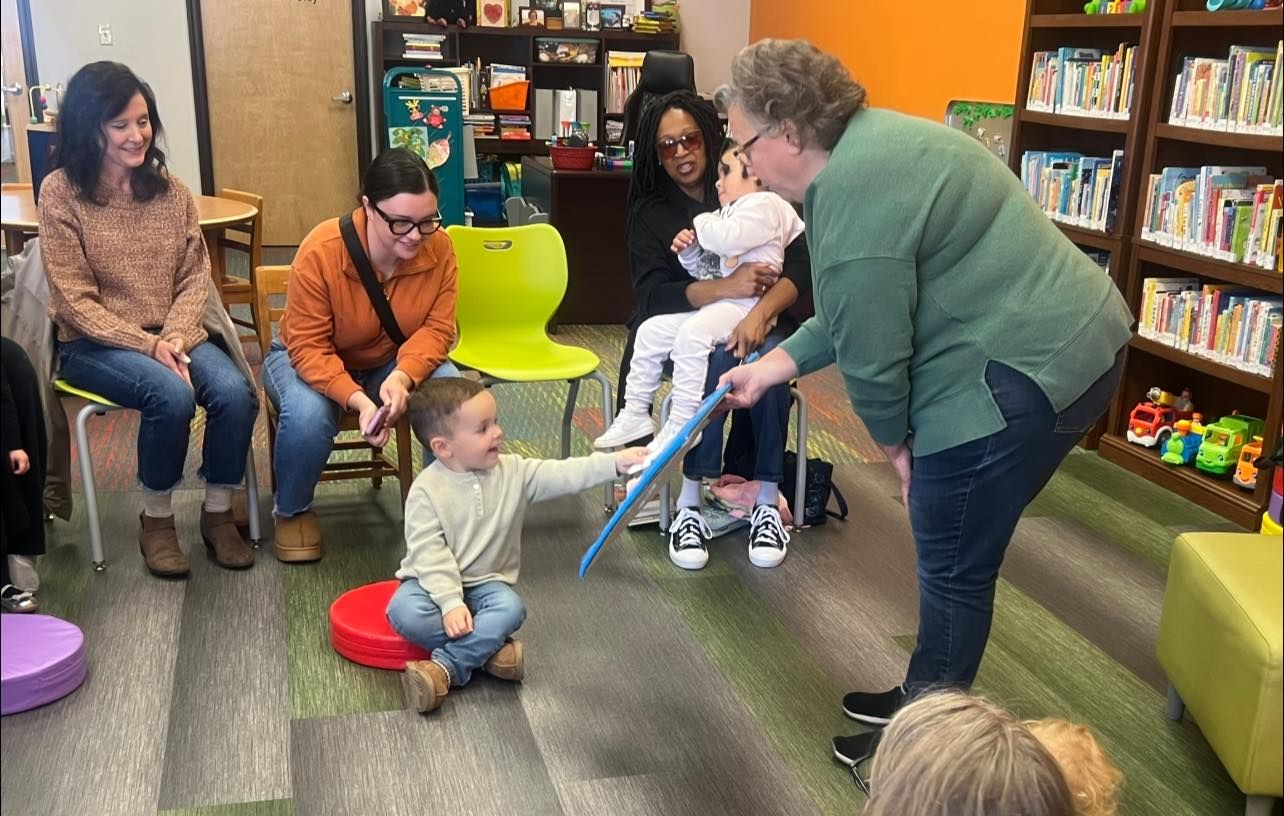 A woman showing a child a toy