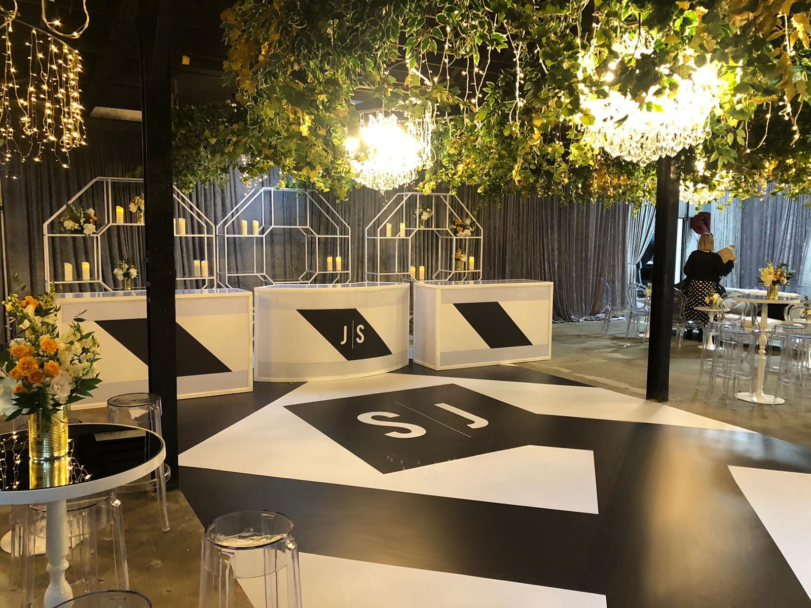 A black and white dance floor in a room with tables and chairs.