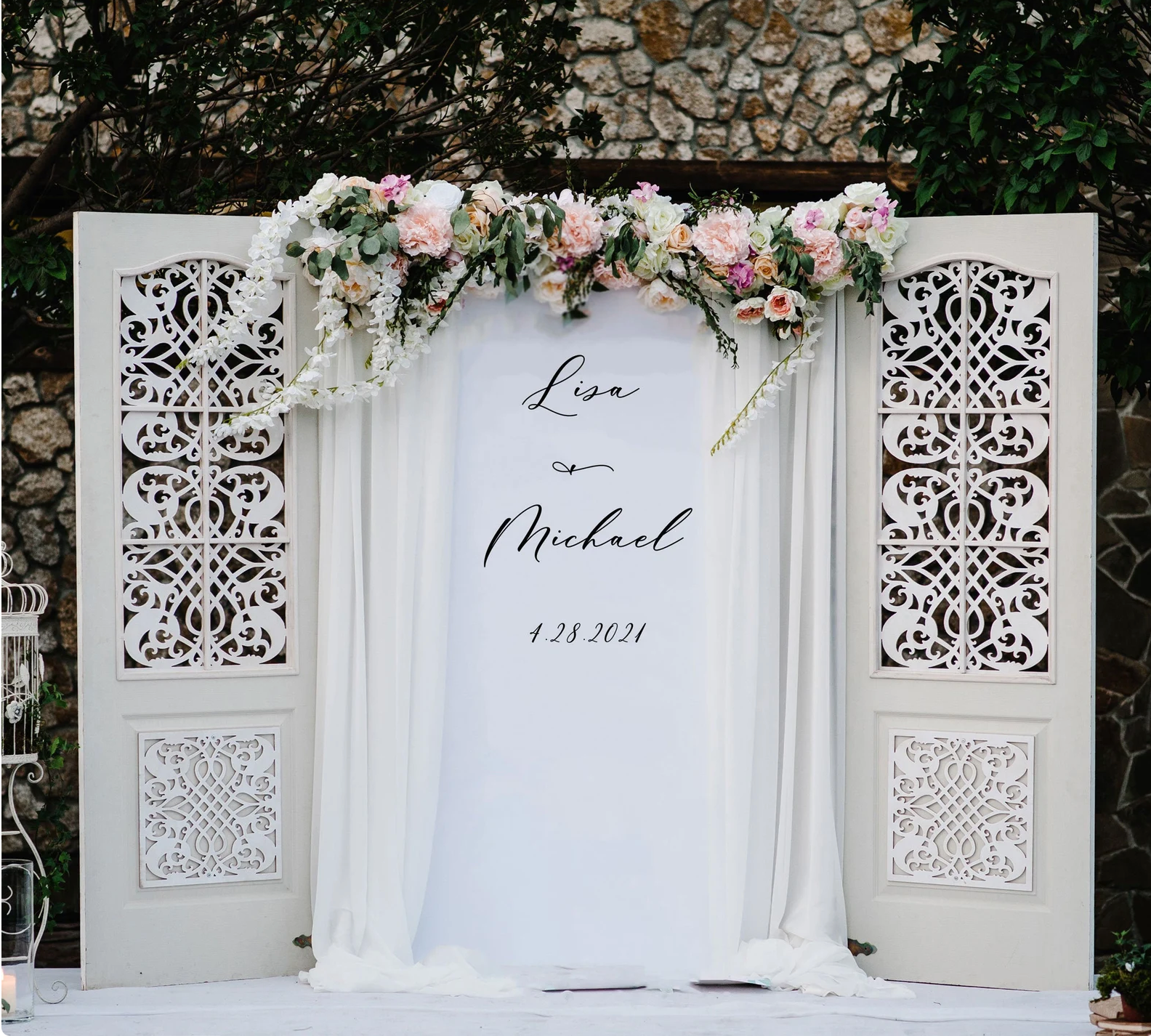 A wedding backdrop with flowers and a sign that says love and michael