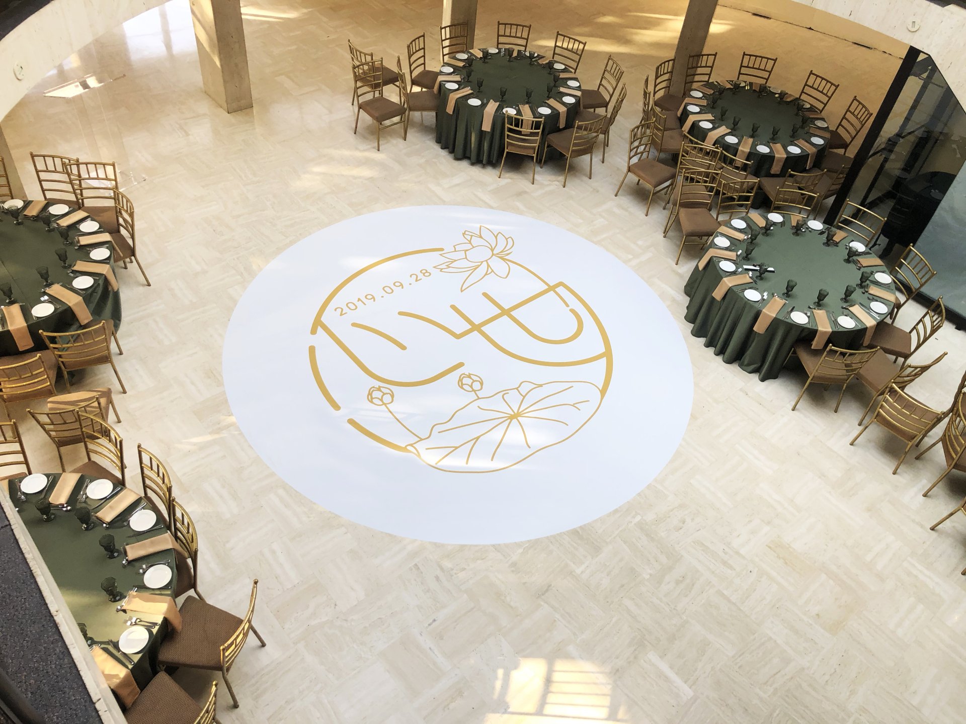 A large room with tables and chairs and a logo on the floor