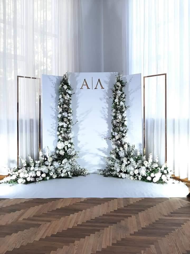 A room with a wooden floor and a white wall with flowers on it.