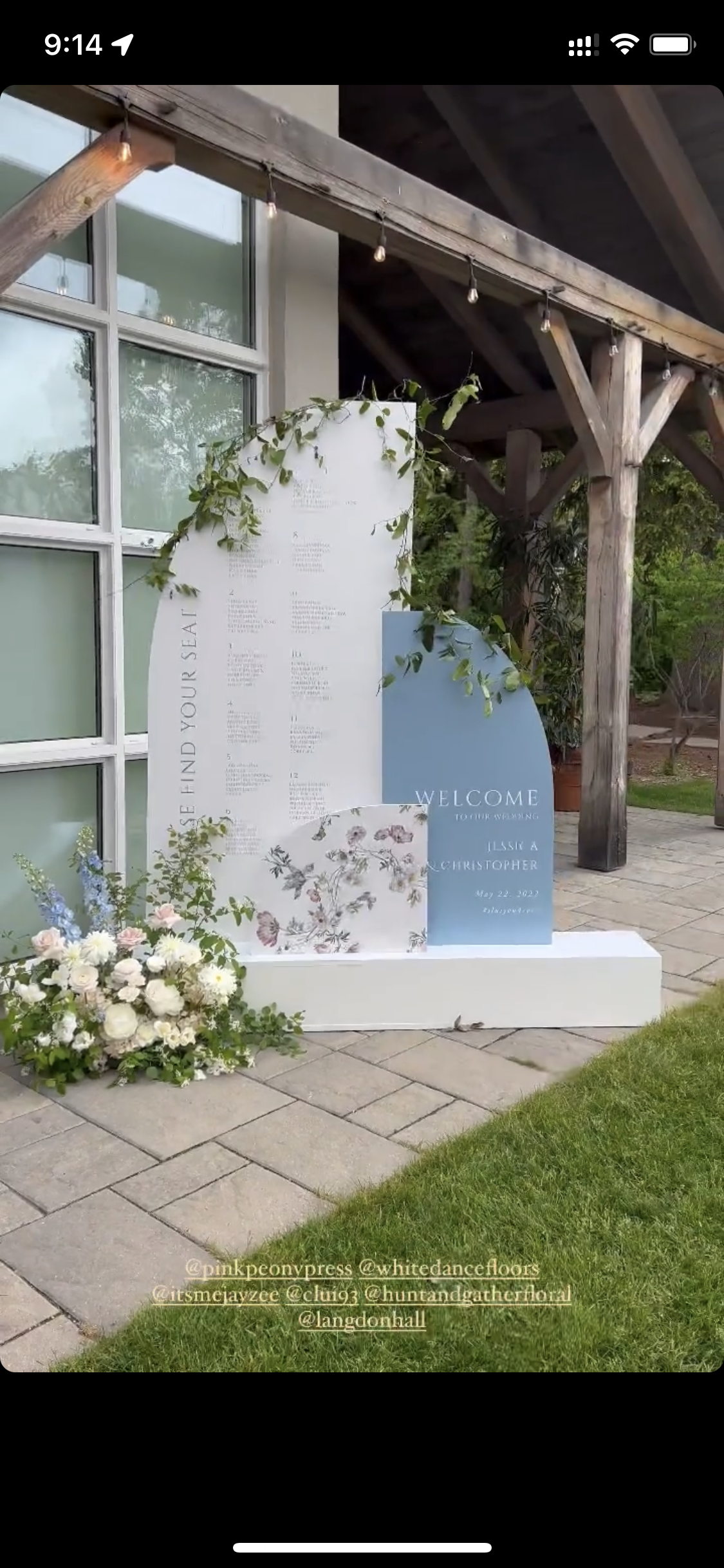 A white and blue wall with flowers in front of a building.