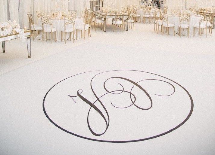A white dance floor with a black monogram on it.