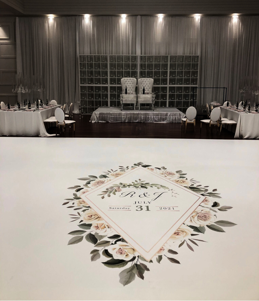A wedding reception with tables and chairs and a dance floor.