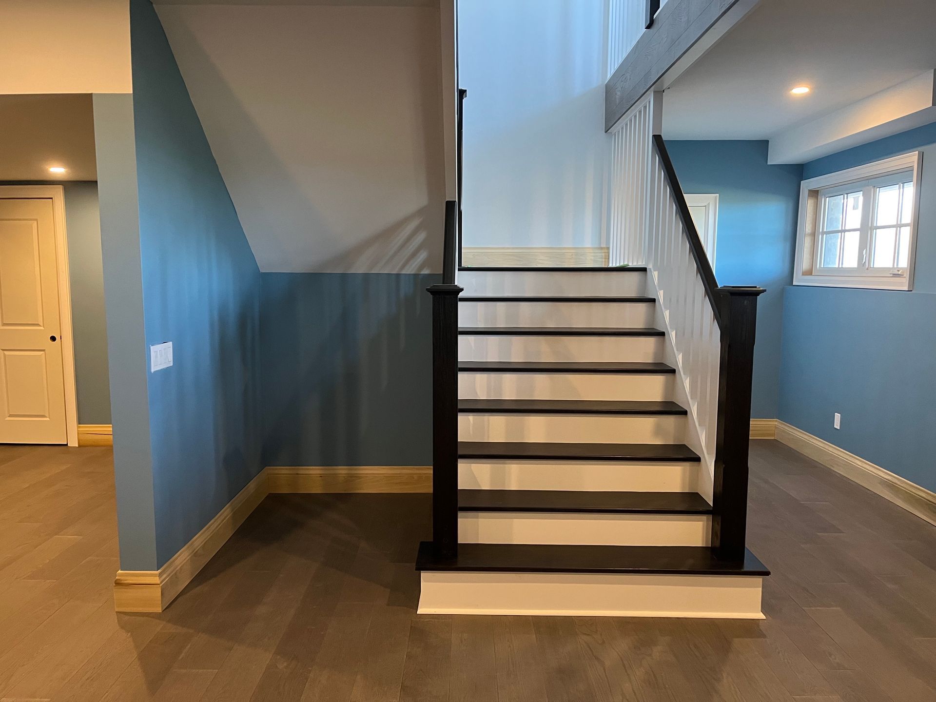 A staircase in an empty room with blue walls