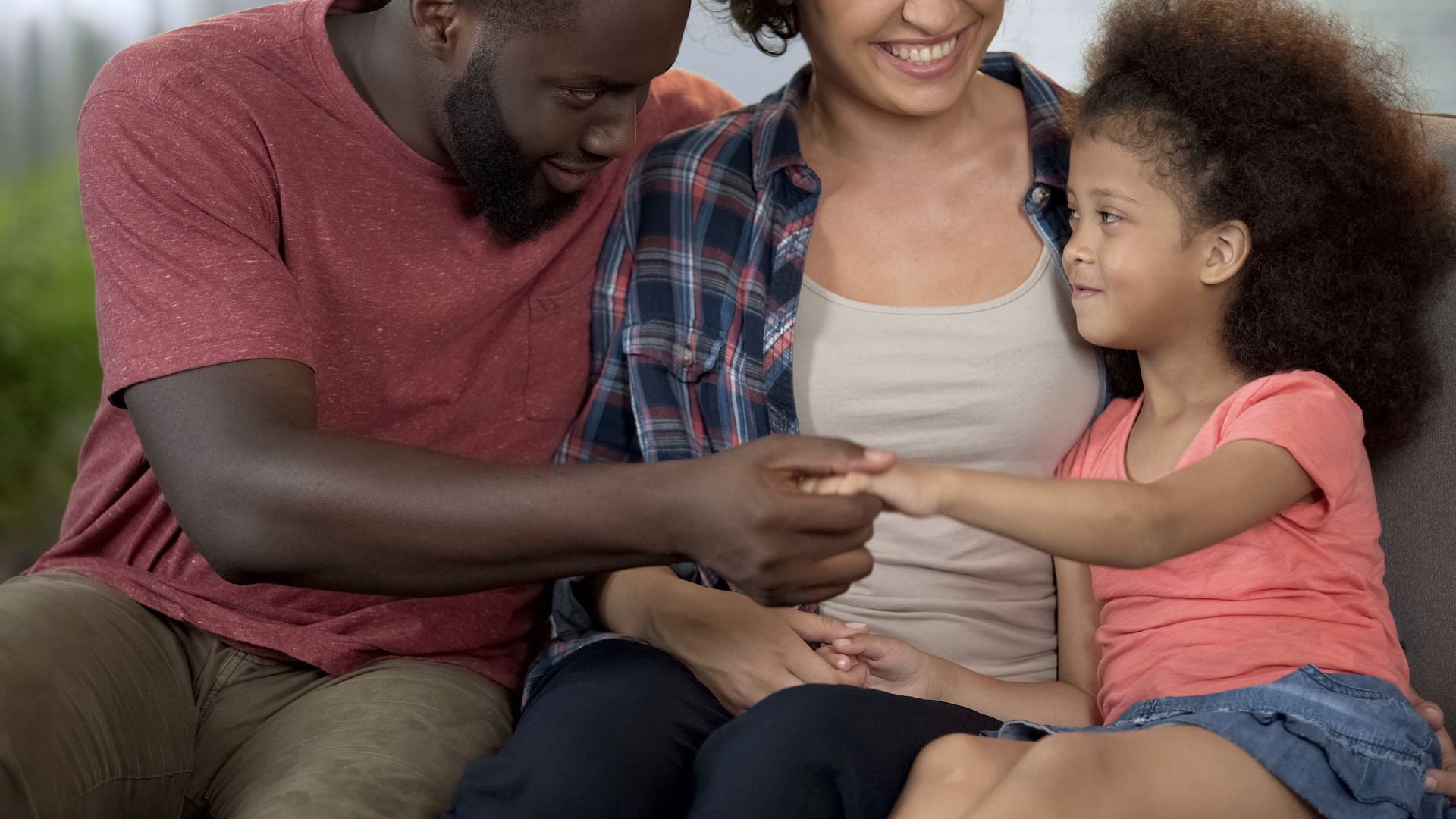 Three women are posing for a picture together and smiling while holding drinks.