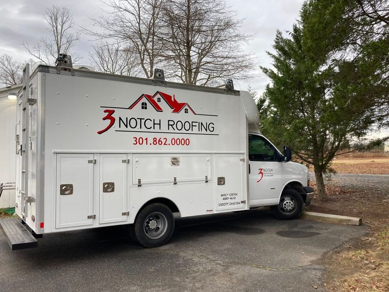 White roofing company truck parked outdoors with “3 Notch Roofing” logo on the side