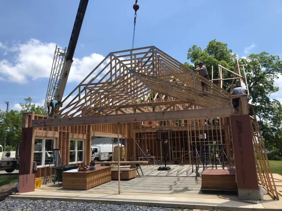 Partially built wooden house frame under construction on a sunny day
