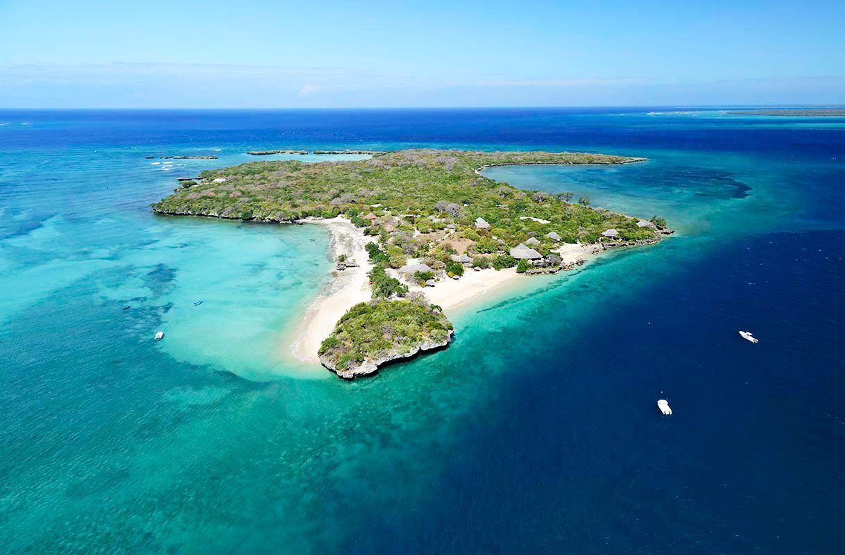 Aerial view of a small tropical island with turquoise water and white sand beaches