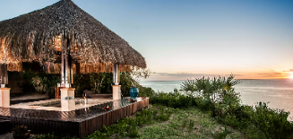 Thatched beach pavilion at sunset overlooking the ocean