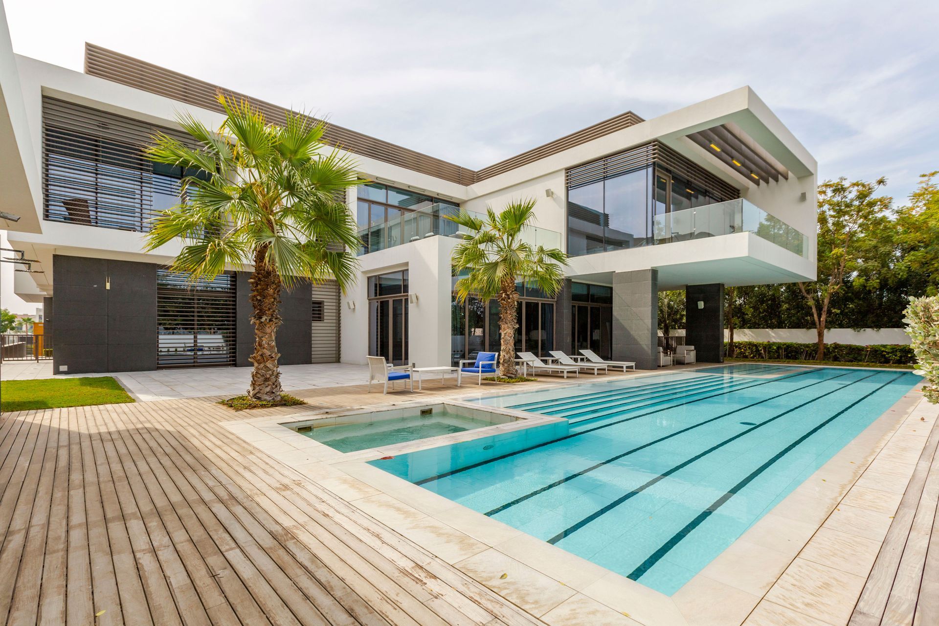 Modern luxury house with a turquoise swimming pool and palm trees