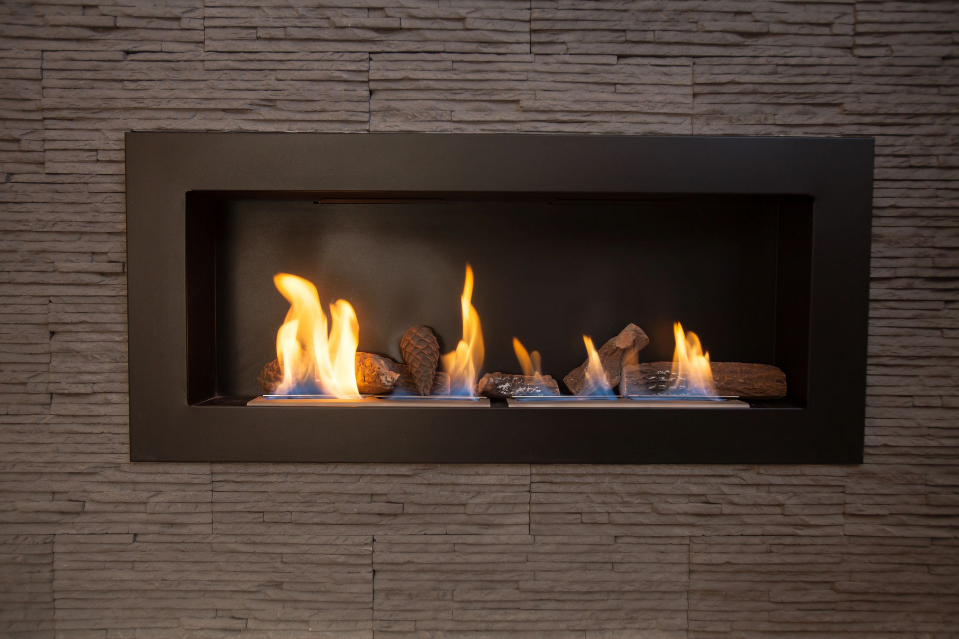 Chimenea moderna de pared con llamas detrás de un marco rectangular negro.