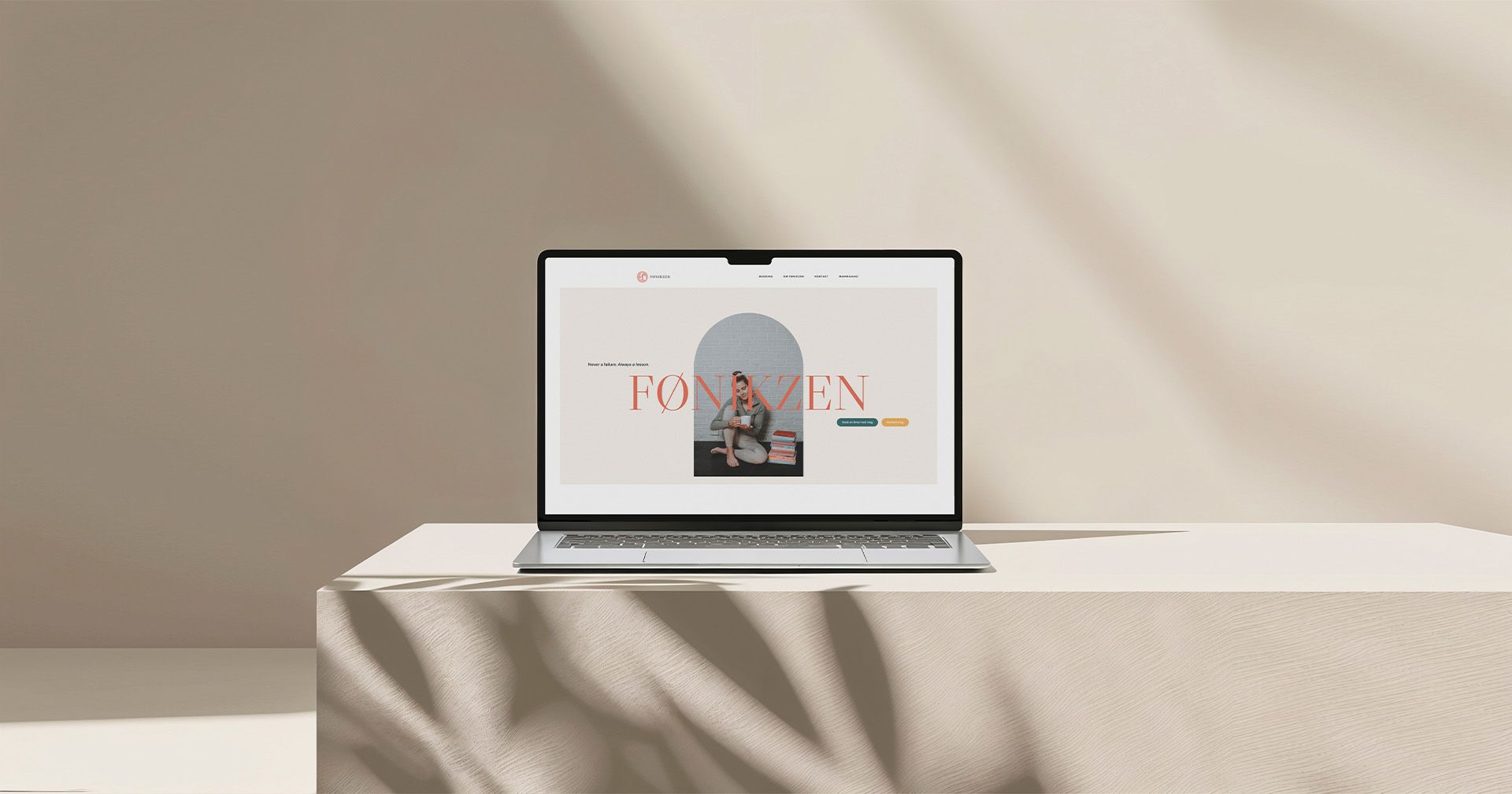 Mockup av Fønikzen nettside. Laptop står på et bord med duk