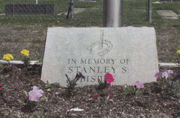 A gravestone in a cemetery that says in memory of stanley s.