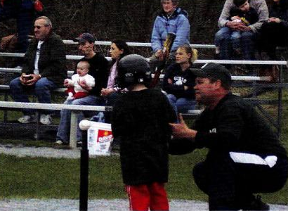 A group of people are sitting in bleachers watching a baseball game