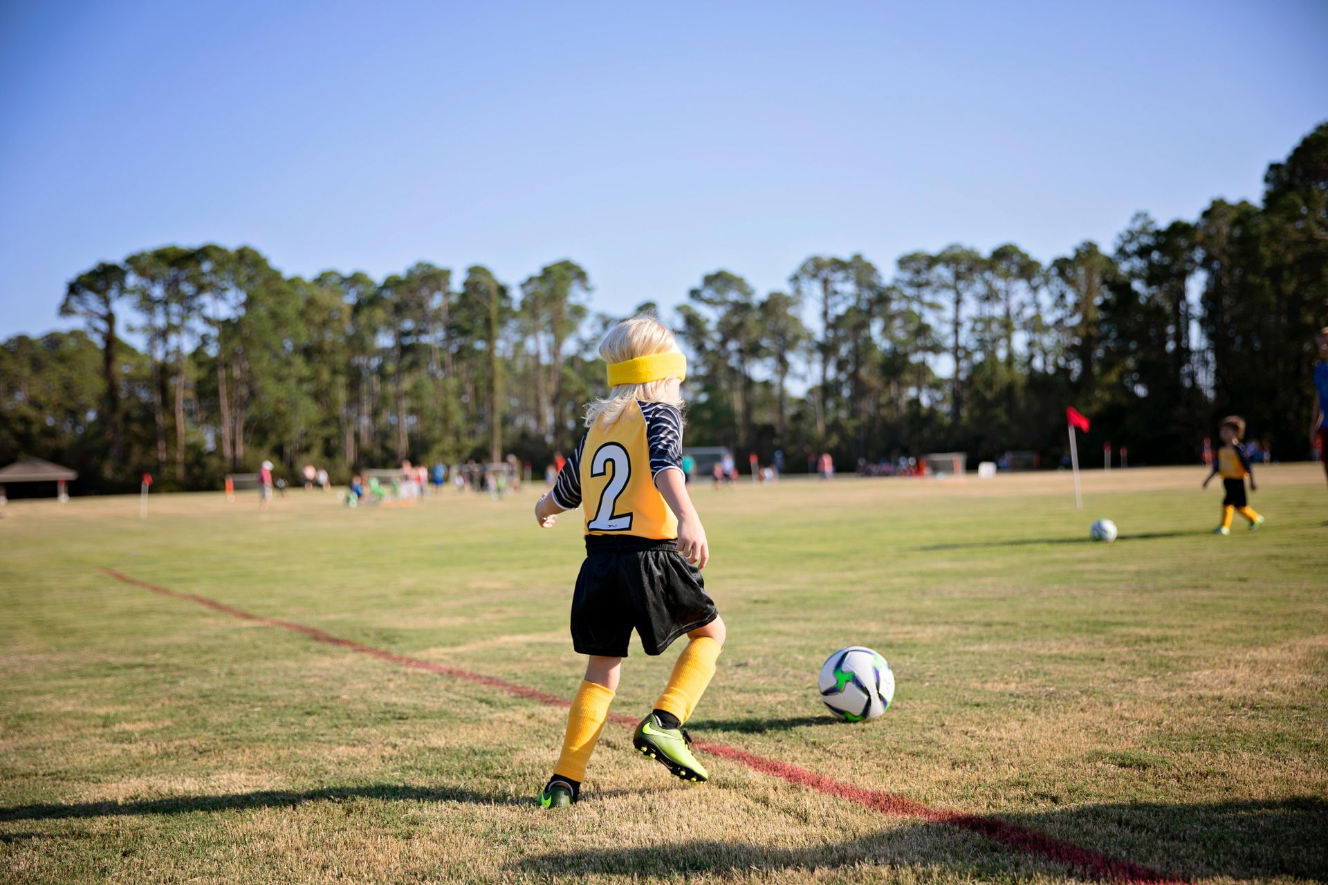 A young boy is kicking a soccer ball on a field.
