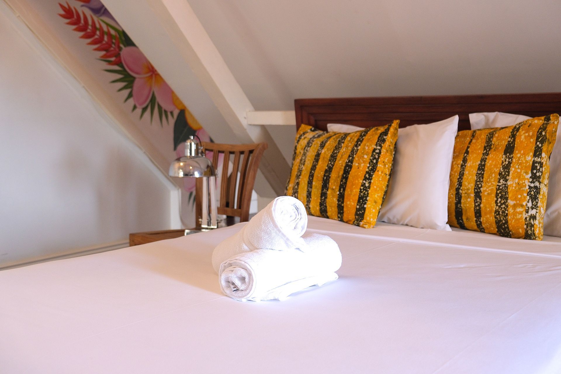 Authentic loft room bed at Bario Hotel with local textiles and warm island ambiance in Otrobanda, Curaçao