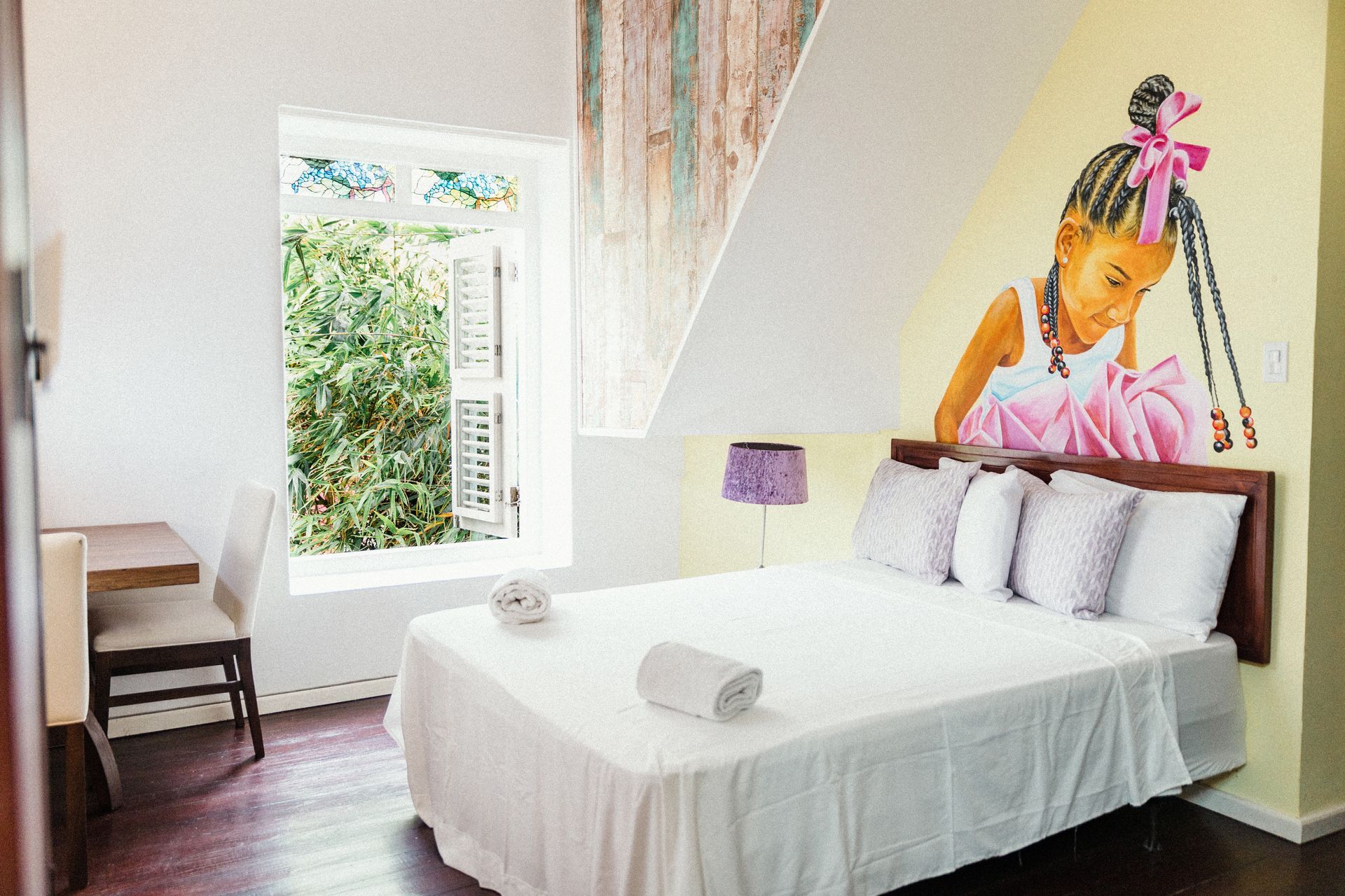 Bright luxe suite with open window overlooking the Otrobanda neighborhood at Bario Hotel, Curaçao