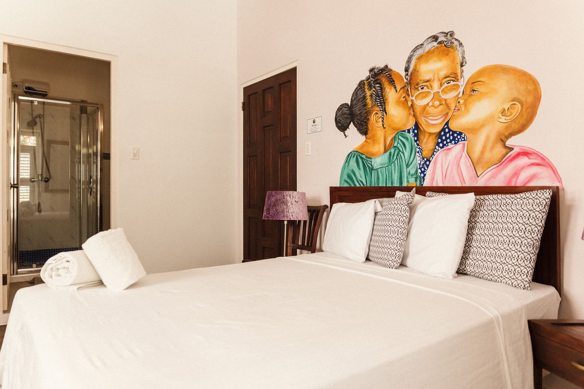 Artistic studio room at Bario Hotel with vibrant local artwork, handcrafted décor, and cozy bedding in Otrobanda, Curaçao