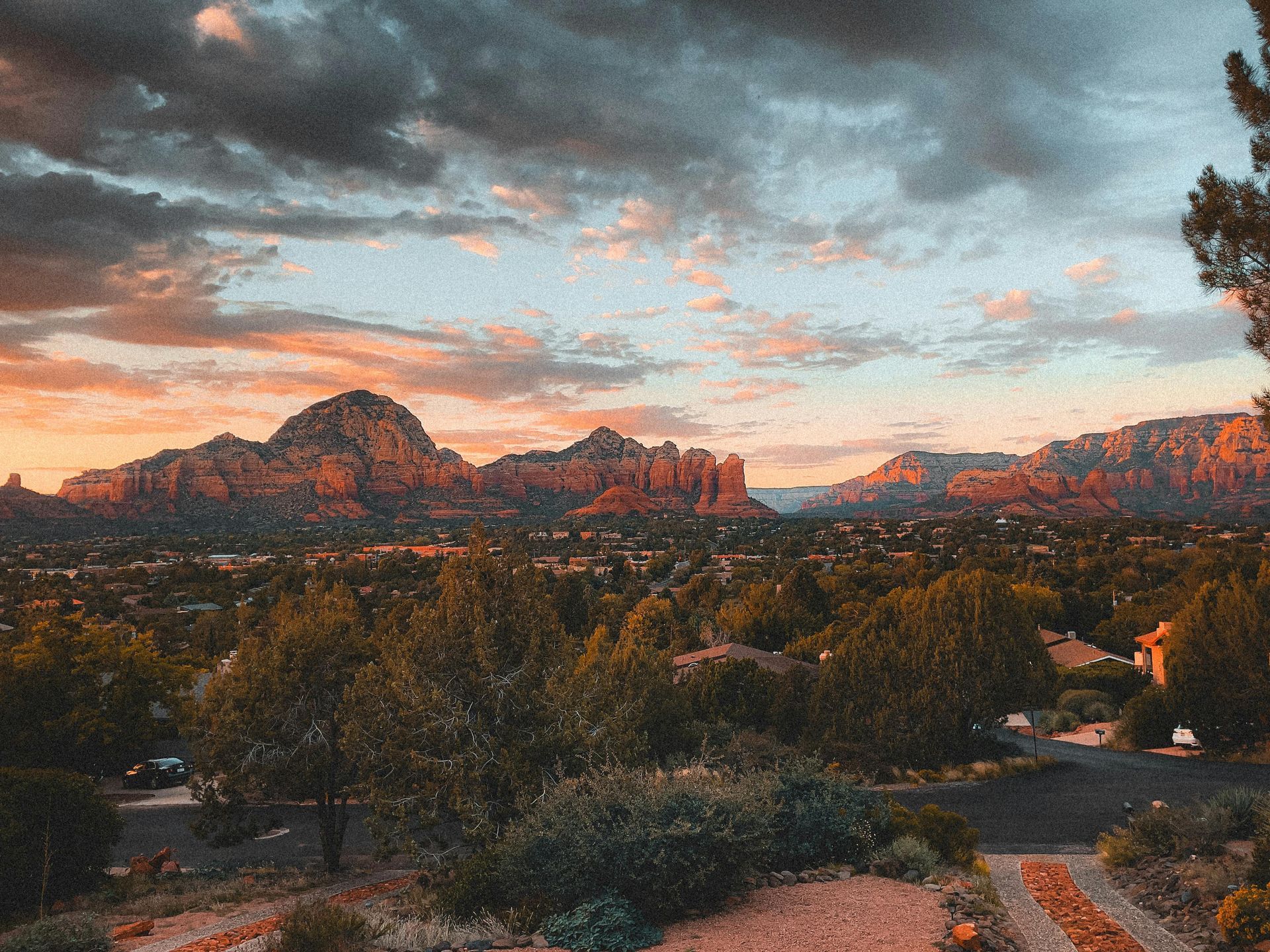 Sunset over red rock mountains with cloudy sky above a desert landscape