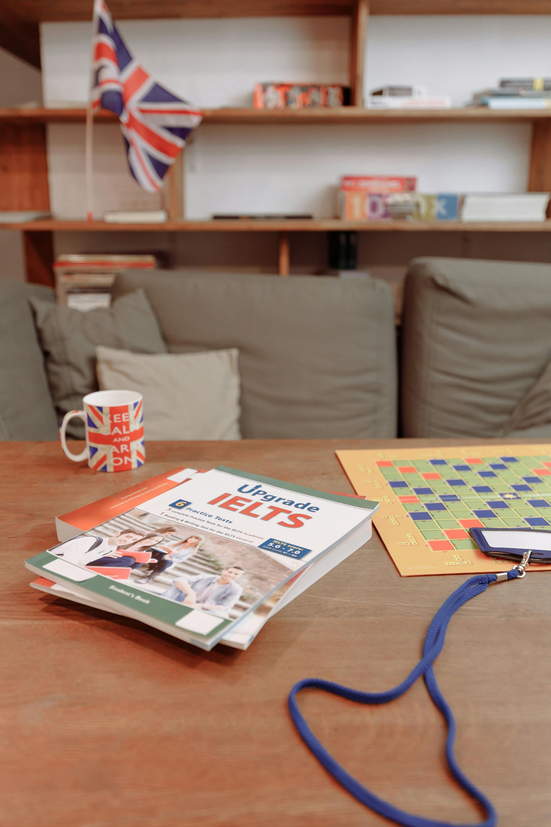 Books, British flag, and a mug with a Union Jack on a table, with a board game.