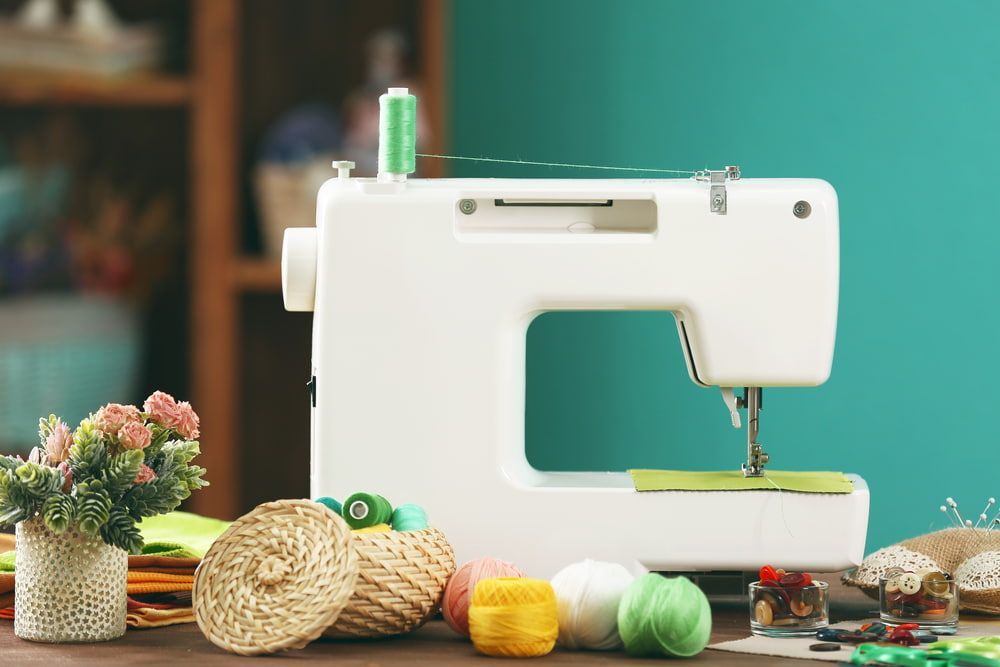 A Sewing Machine Is Sitting On A Table Next To Yarn And Flowers — Bernina Sewing Centre In Mackay, QLD