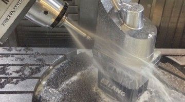 A machine is cutting a piece of metal on a machine.