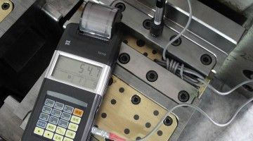 A calculator is sitting on top of a machine with a thermometer attached to it.