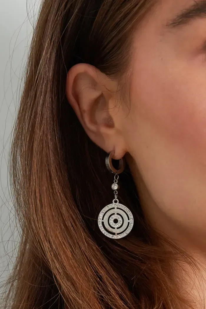 Een close-up van een vrouw die een paar oorbellen draagt.