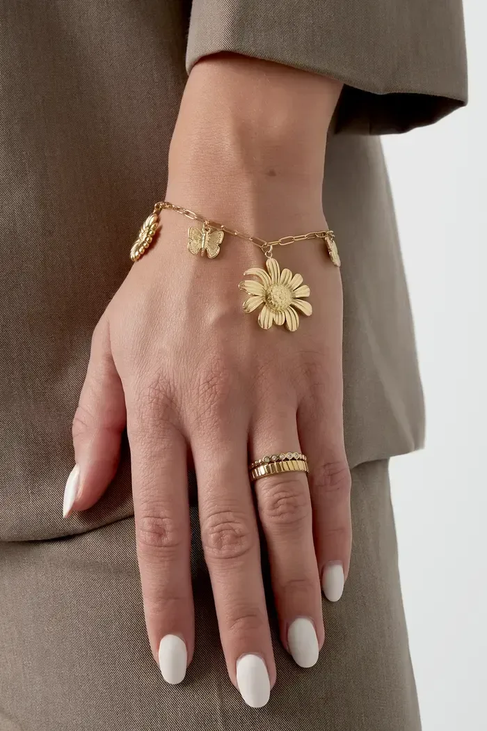 Een vrouw draagt ​​een armband en een ring om haar pols.