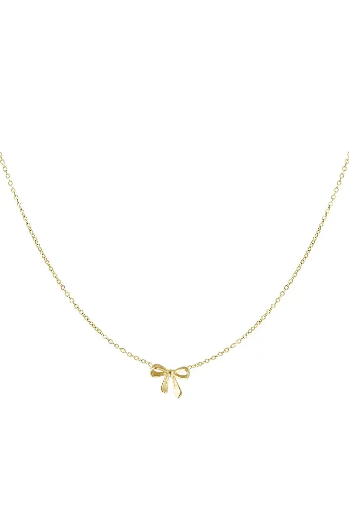 Een gouden ketting met een strik als hanger op een witte achtergrond.