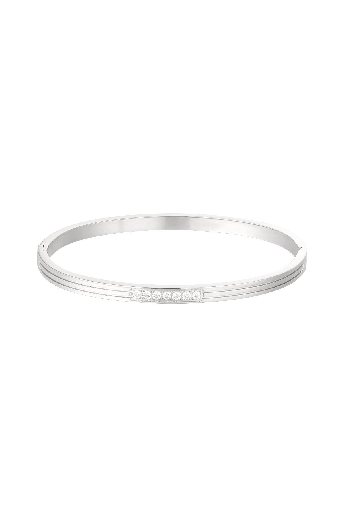 Een vrouw met drie zilveren armbanden om haar pols